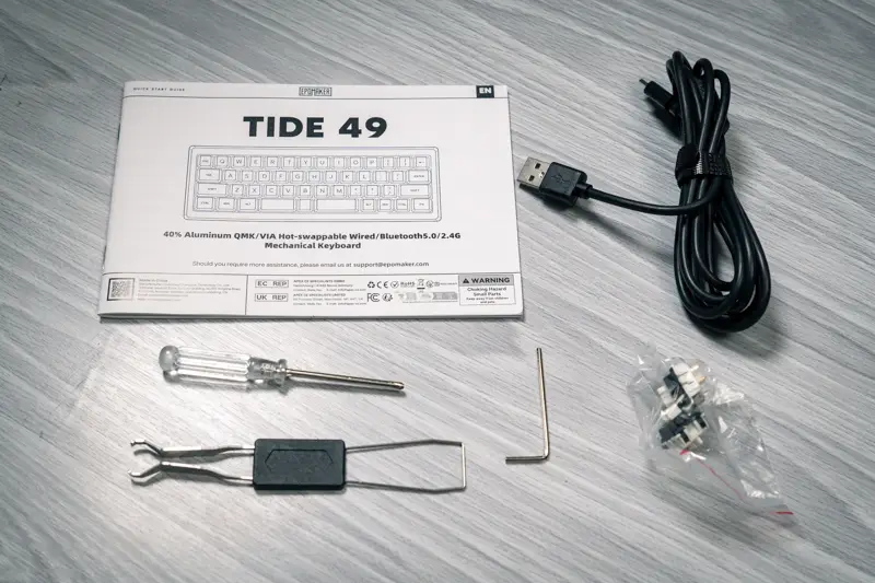 Epomaker Tide49の付属品の写真 マニュアル キースイッチ/キーキャッププラー 充電兼有線接続用USB-Cケーブル 予備キースイッチ x 2 プラスドライバー 六角レンチが写っている